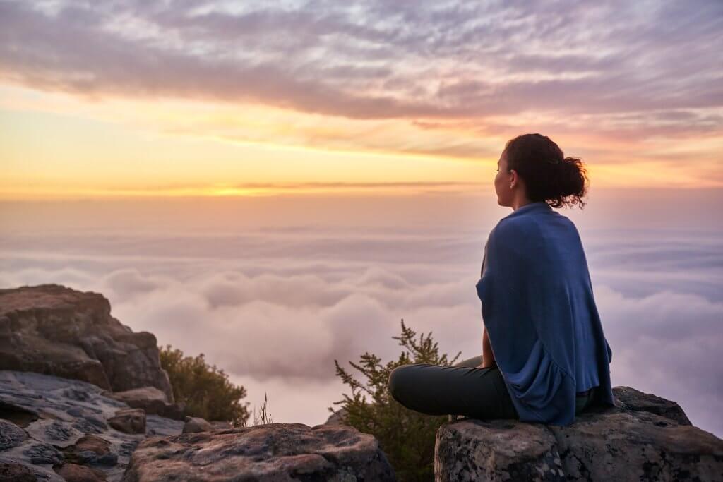 Chinese Medicine practitioner meditating on mountain